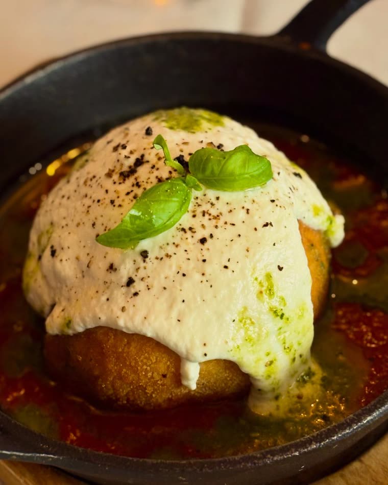 Arancino sobre molho de tomate e creme de mozzarella